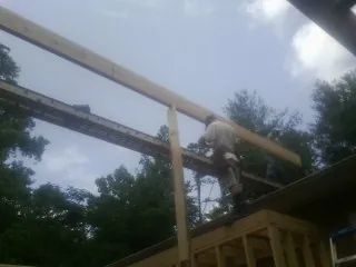 Carpenter setting a ridge beam over a new addition frame — Ice Dam Removal by Roofing Brothers in Scio